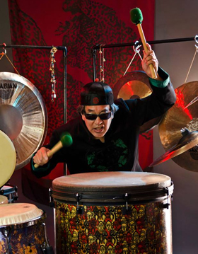 Eric Chun, Proud User and Endorser of Bag End Loudspeakers is shown playing the drums